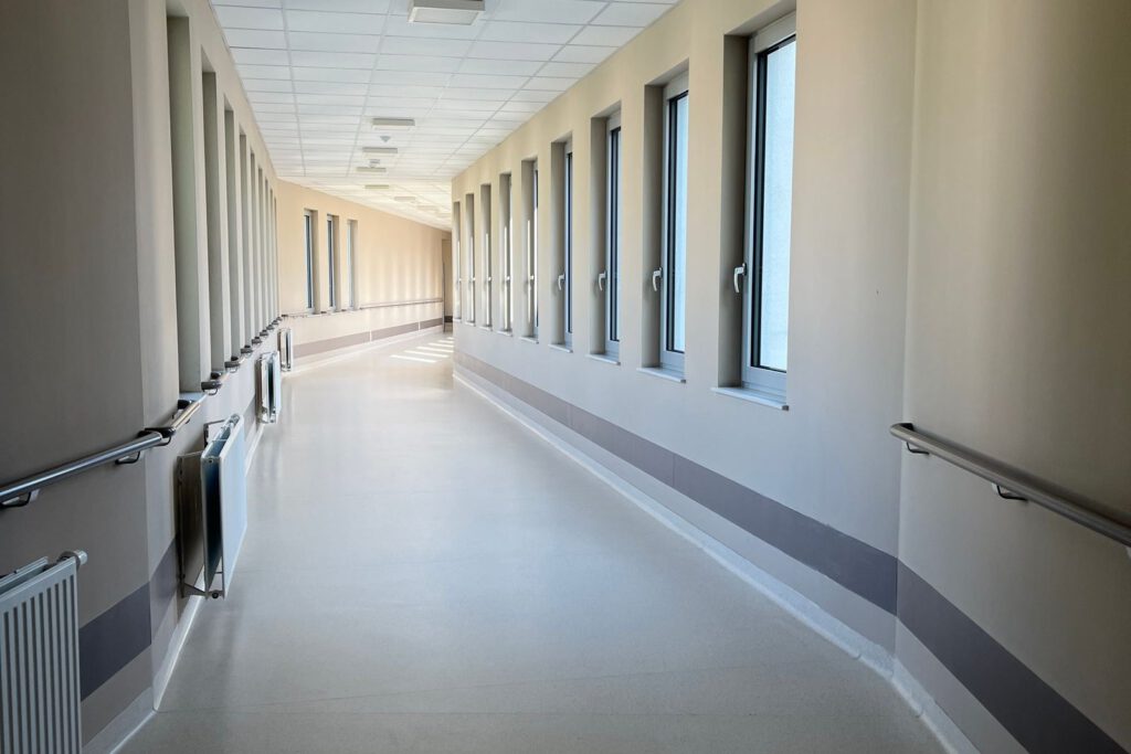 Heller Klinikflur mit Handläufen und glattem Boden – Rutschschutz für Krankenhaus und Pflegeheim